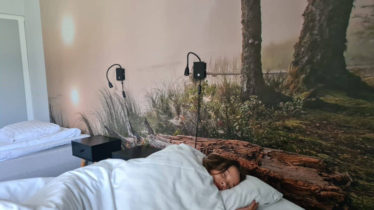 Tyttö nukkuu makeasti valkoisissa lakanoissa Kunnonlähteen hotellissa.