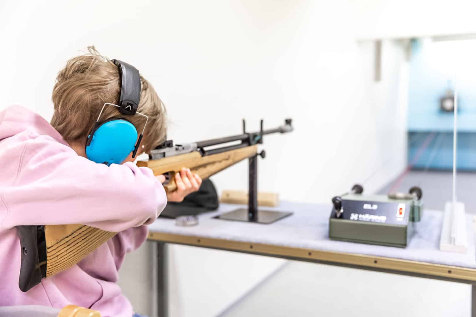 Poika tähtää tauluun ilma-aseella Kunnonlähteen ampumaradalla.