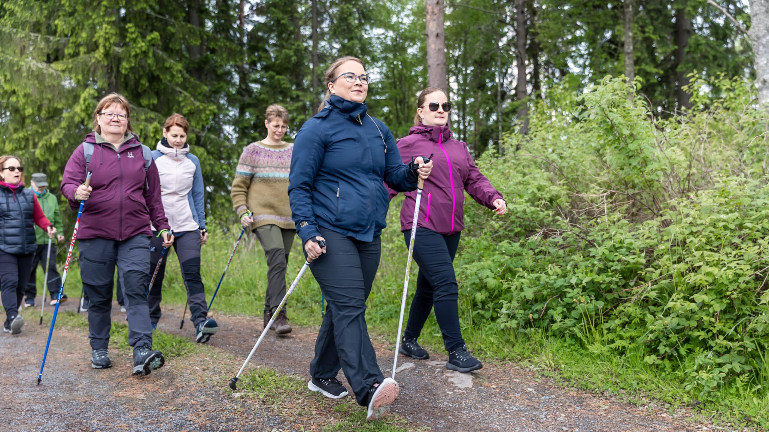 Tules-kurssin porukka kävelee reippaasti metsäisellä tiellä.